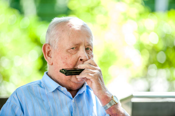 Portrait Of Senior Man Playing Harmonica