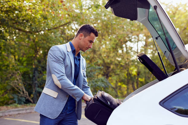 istock Man puts the suitcase in the trunk 871519558