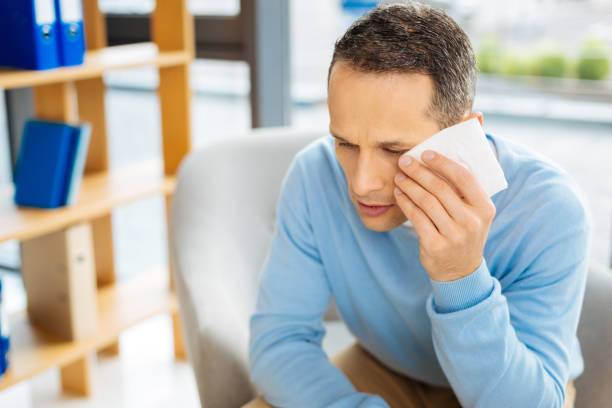 istock Unhappy sad man wiping away his tears 871524854
