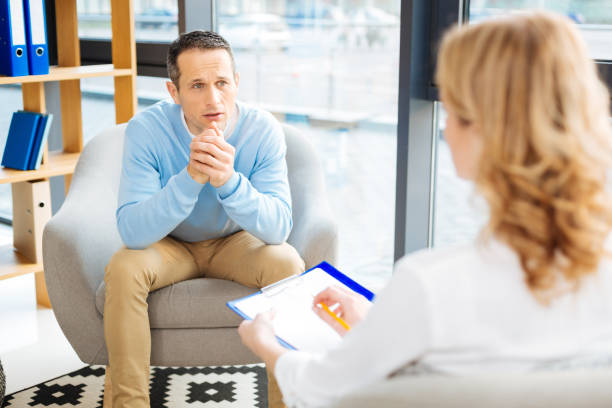 istock Sad gloomy man looking at his therapist 871525704