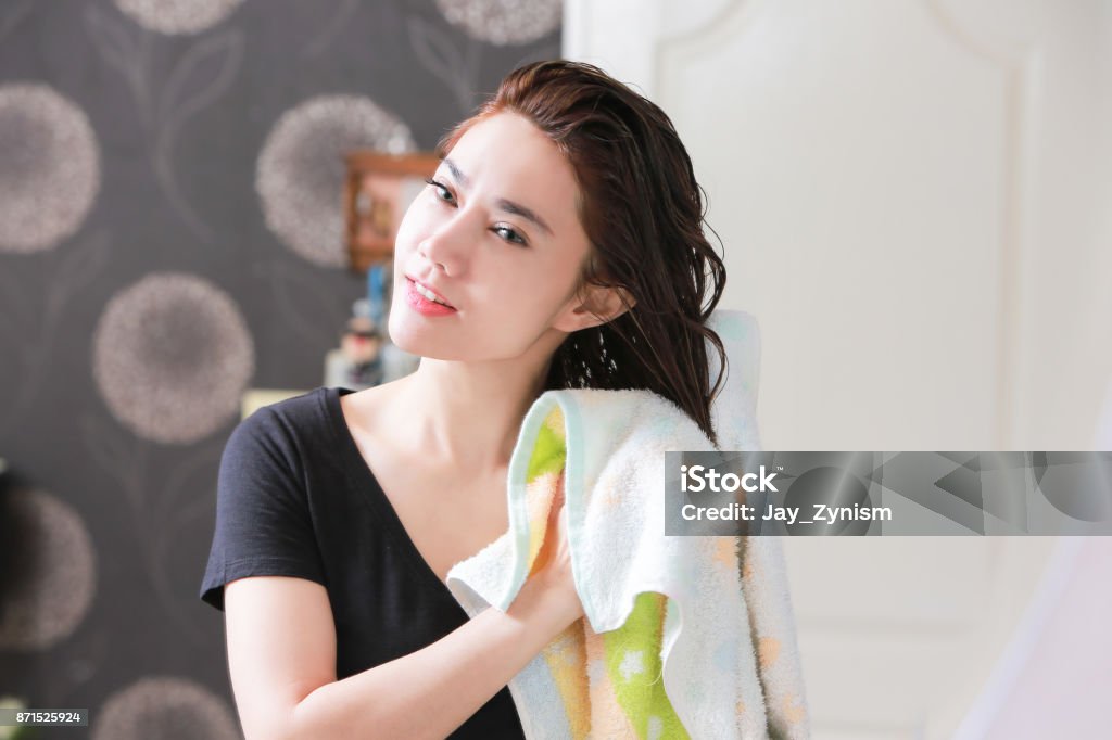 Beautiful Young Female After Bath Applying Hair Oil. Hair Stock Photo