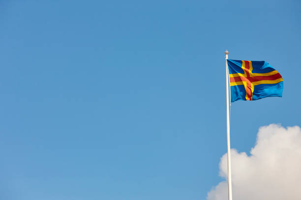 Aland islands flag over a blue sky. Finland background. Aland islands flag over a blue sky. Finland background. Horizontal åland islands stock pictures, royalty-free photos & images