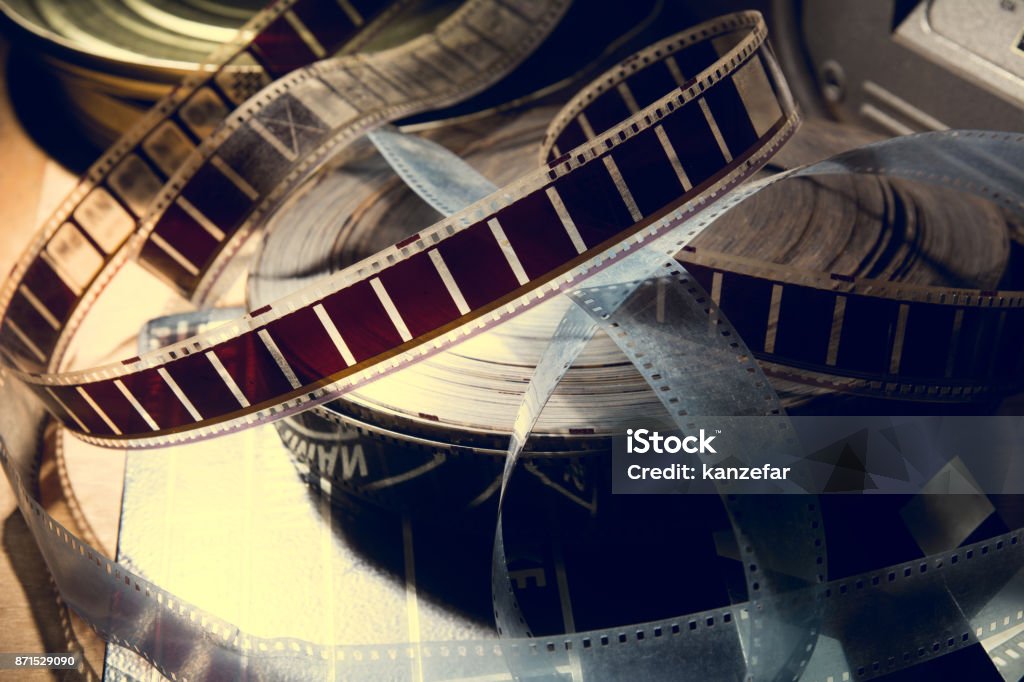 An old film with a movie on the roll. An old film with a movie on the roll. Background for advertising old cinema Film Industry Stock Photo