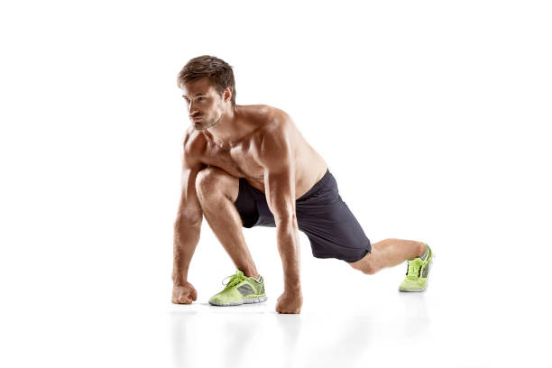 Portrait of strong young muscular man stretching his arms. Fitness african male model standing over dark background
