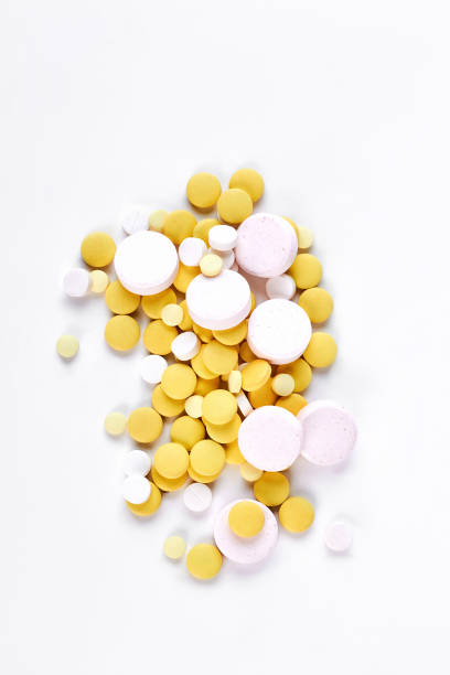 istock Pile of white and yellow pills. 871540412