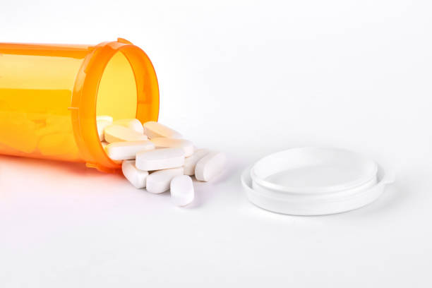 istock White pills spilled from pills bottle. 871541044