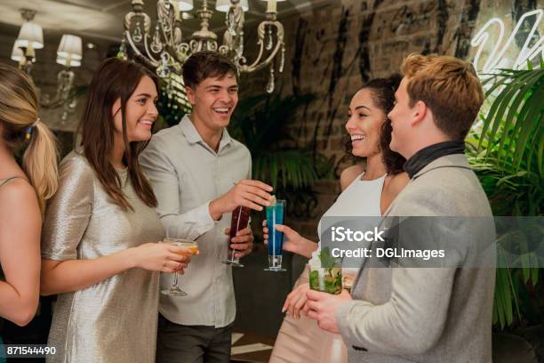 Friends Socialising Over Cocktails Stock Photo - Download Image Now - Cocktail Party, Business, Young Adult