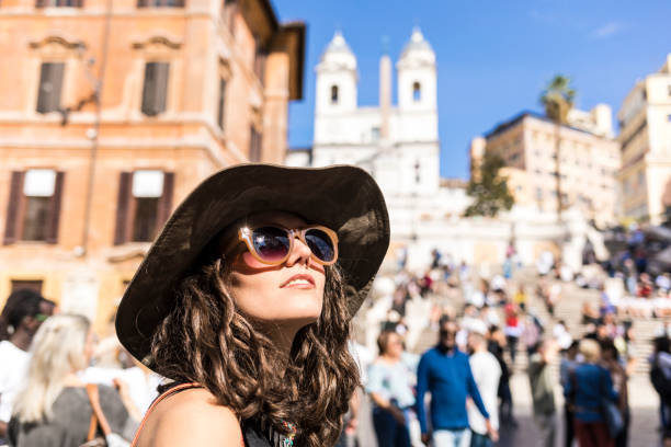 Elegant tourist taking pictures in front of Spanish steps on Piazza di Spagna