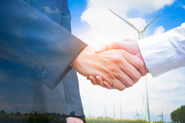 istock Double exposure of handshake with wind turbine. Ecology concept 871544818