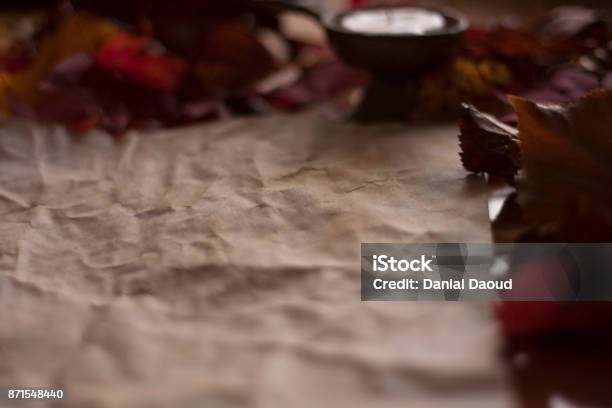 Empty Old Paper With A Candle And Leafs On Wooden Table Stock Photo - Download Image Now