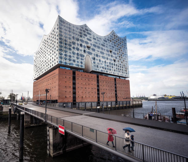 Hamburg, Germany - People walking in the Hafencity harbour district of Hamburg, with the facade of the Elbphilharmonie Concert Hall in the background.