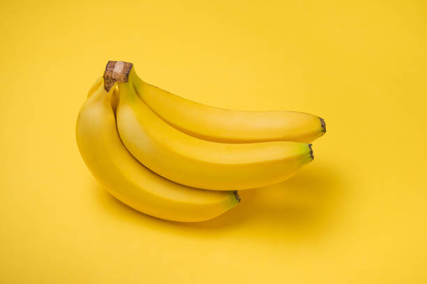 istock A banch of bananas on yellow background. 871551228