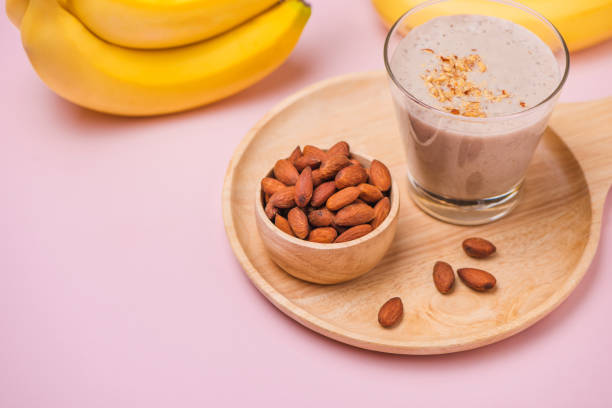 istock Fresh made banana smoothie in a glass on pink background 871553358