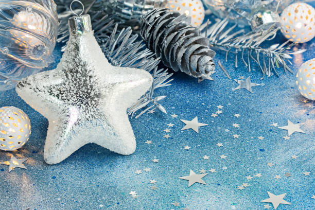 istock silver star, holiday lights and silver cones for christmas tree decoration on blue background 871553472