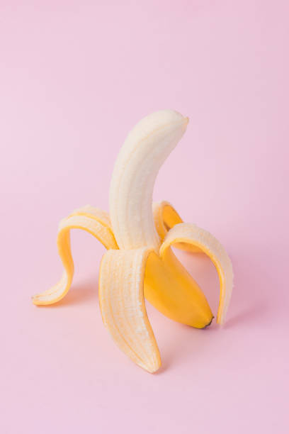 istock Fresh peeled banana on pink background 871554442