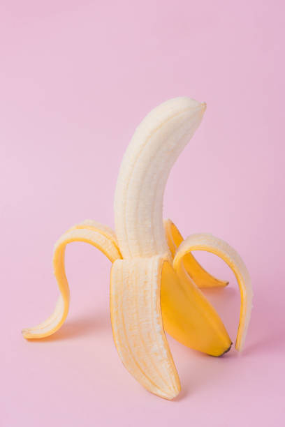 istock Fresh peeled banana on pink background 871554732