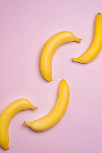 istock Top view. Group of bananas on pink background. 871555036