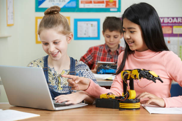 istock Female Pupils In Science Lesson Studying Robotics 871563936