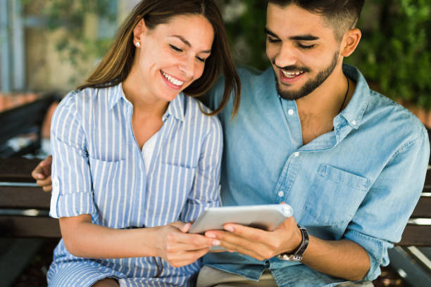 istock Young attractive couple on date sitting on bench 871565820