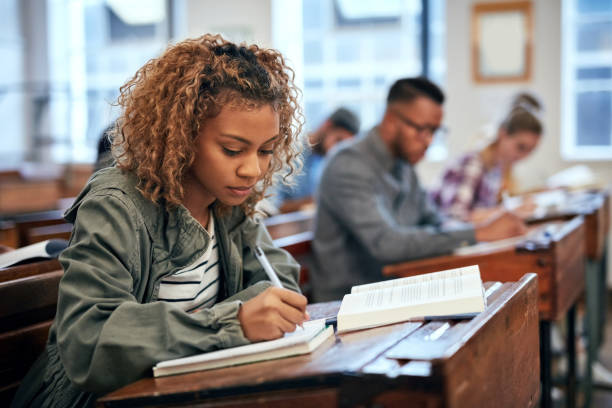 She is ready for the exam because she studied Cropped shot of university students sitting in class exam student university writing stock pictures, royalty-free photos & images