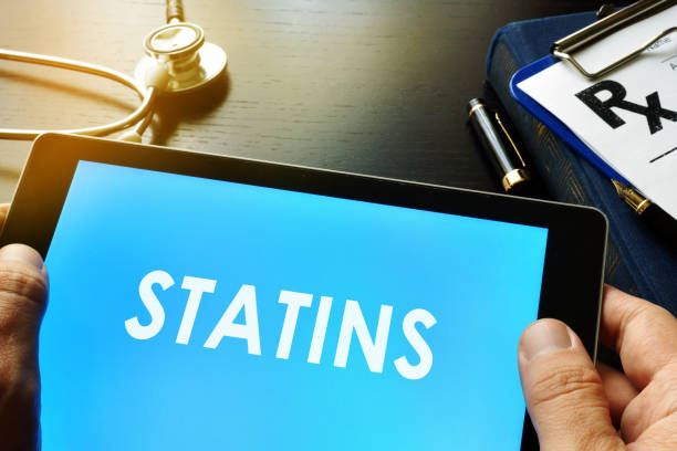 Doctor holding a tablet with word statins. Doctor holding a tablet with word statins. statin stock pictures, royalty-free photos & images
