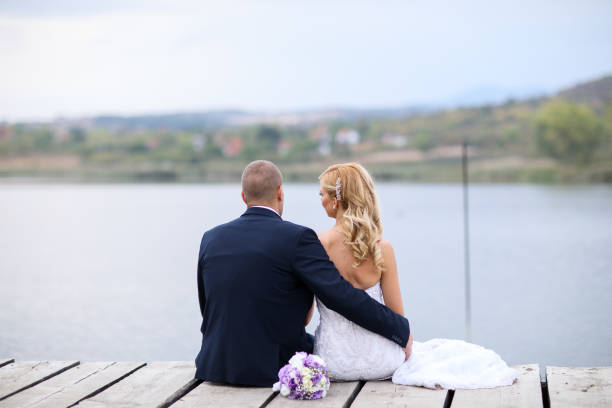 istock Wedding couple on lake pier 871574142