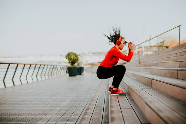 istock Young woman exercising jumping outside 871577428