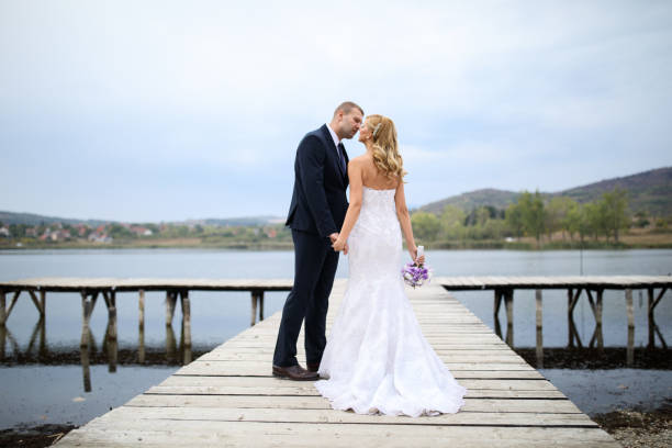 istock Wedding couple on lake pier 871580882