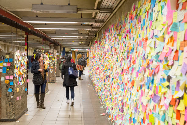 Sticky post-it notes in NYC subway station New York, United States of America - November 21, 2016: People looking at sticky post-it notes on wall in Union Square subway station which were set up as protest against presidential election results union square new york city stock pictures, royalty-free photos & images