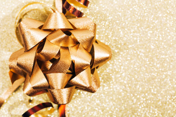 istock Golden ribbon bow with little sparkles in bokeh 871581476