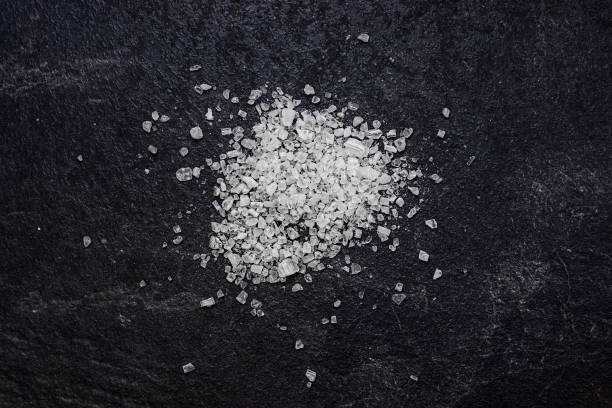 istock Sea salt on a black background. Ingredients for cooking. 871582148