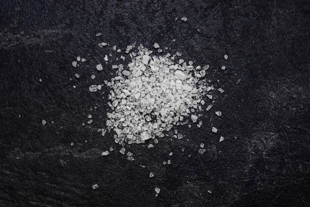 Sea salt on a black background. Ingredients for cooking. stock photo
