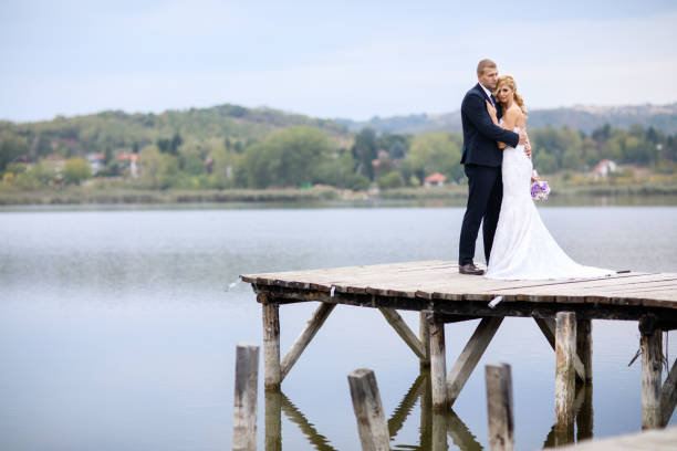 istock Wedding couple on lake pier 871584270