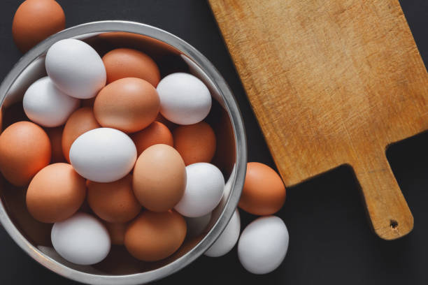istock Fresh brown eggs in bowl isolated on black background 871584670