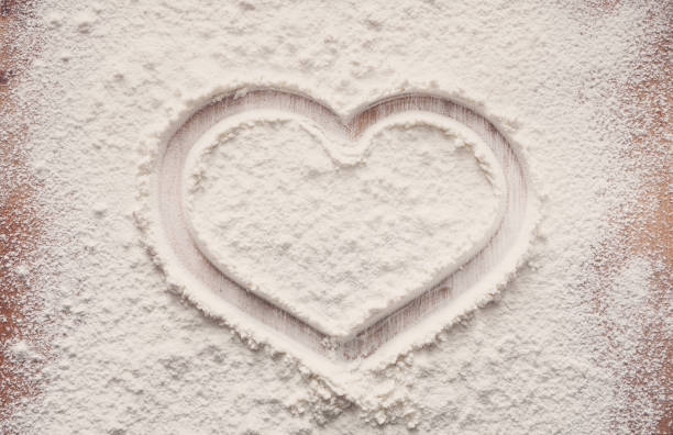 istock Baking concept on wood background, sprinkled flour with heart, copy space 871585242