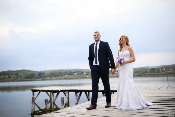 istock Wedding couple on lake pier 871588732