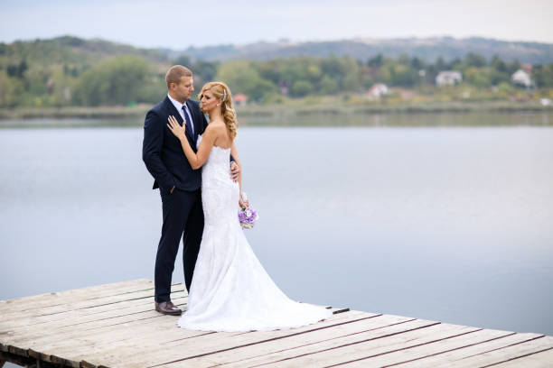 istock Wedding couple on lake pier 871594794