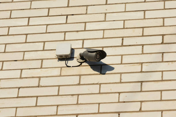 istock Security video CCTV camera is mounted on a brick house wall for protection. Security Camera. 871597622