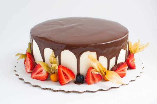 istock Birthday cake in chocolate with strawberries, blueberries and physalis on white background. 871597726