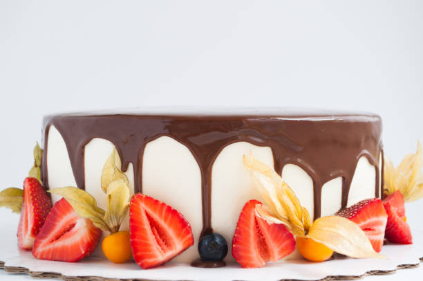 istock Birthday cake in chocolate with strawberries, blueberries and physalis on white background. 871597734