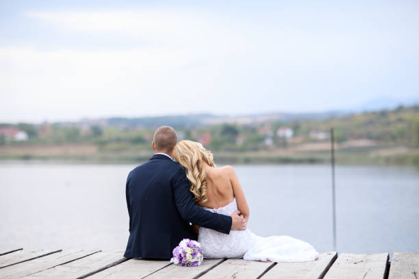 istock Wedding couple on lake pier 871598014