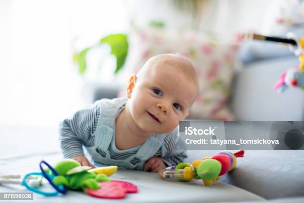 Cute Baby Boy Playing With Toys In A Sunny Living Room Stock Photo - Download Image Now