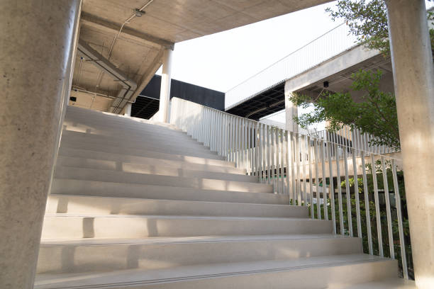istock Light and shadows of white iron bar projected onto the white stairway. 871606290