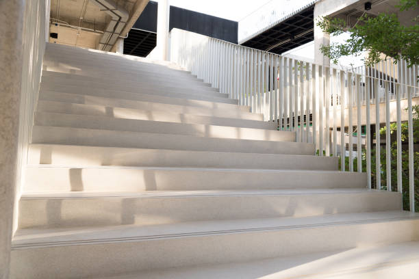 istock Light and shadows of white iron bar projected onto the white stairway. 871606356
