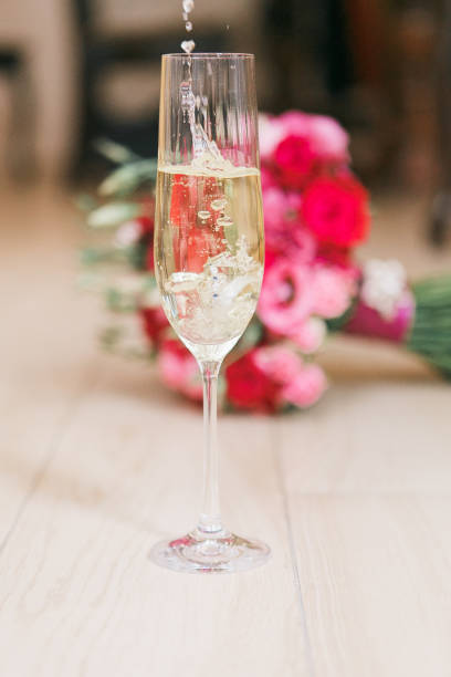 istock Luxury champagne glass with wedding bouquet on background. 871609242