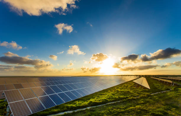 Solar panels at sunrise with dramatic cloudy sky in Normandy, France. Modern electric power production technology. Environmentally friendly electricity production stock photo