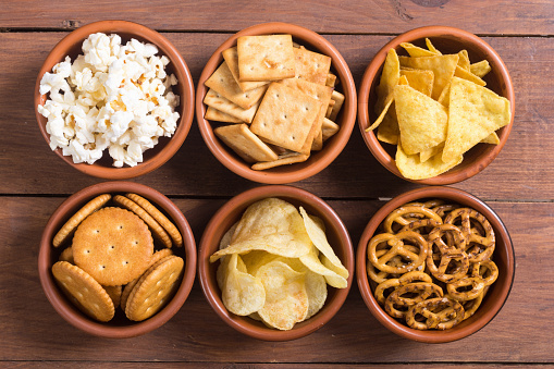 Mix of snacks : pretzels , crackers , chips , popcorn , nuts and nachos