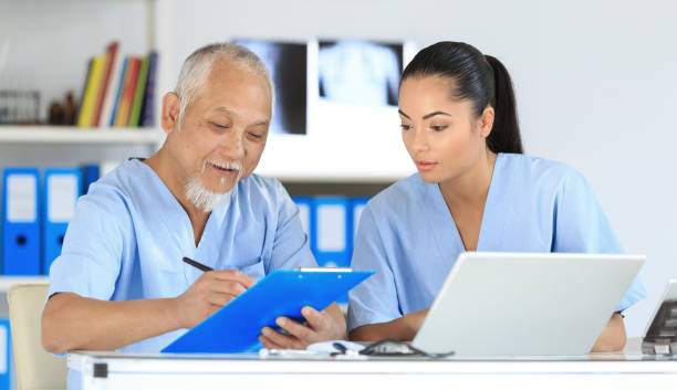 istock Medical student and senior doctor filling documents 871620962