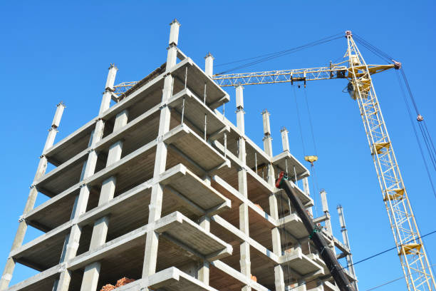istock Building cranes on construction site with builders. Building high rise.Crane Construction. Tower Crane and Building Constructors on Construction Site. 871628582