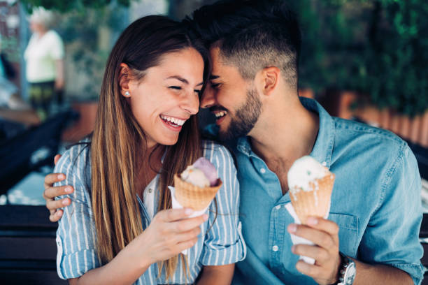 coppia felice che ha un appuntamento e mangia gelato - data scritta foto e immagini stock